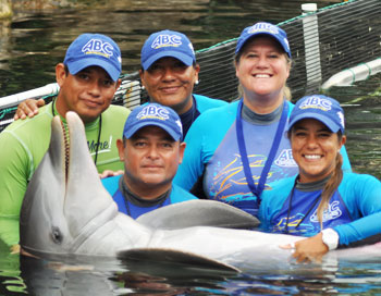 Future marine mammal trainers at ABC Animal Training pose for a photo with a happy  dolphin